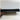 Thumbnail for A close-up of a black multi-pin electronic connector plug held by a hand against a plain light background.