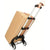A silver and black aluminum rolling dolly with a red elastic band, being pulled by a hand carrying the handle, with a large brown cardboard box strapped on top, against a plain white background.