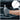 Thumbnail for A person wearing a gray knit work glove holds a silver ratcheting wrench in front of an open car hood. A circular inset at the top right shows the wrench alone on a white background.