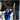 Thumbnail for A mechanic in a blue uniform uses a cordless ratchet wrench to work underneath a vehicle on a lift in a garage.